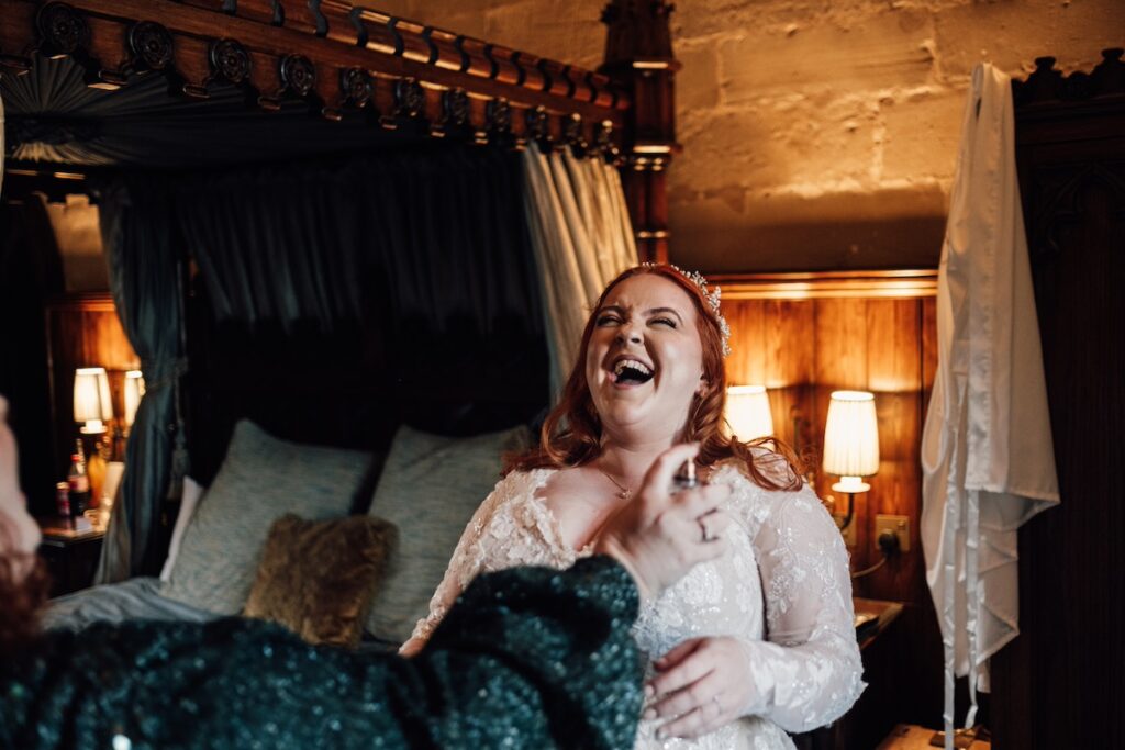 Bride laughing at being sprayed with too much perfume