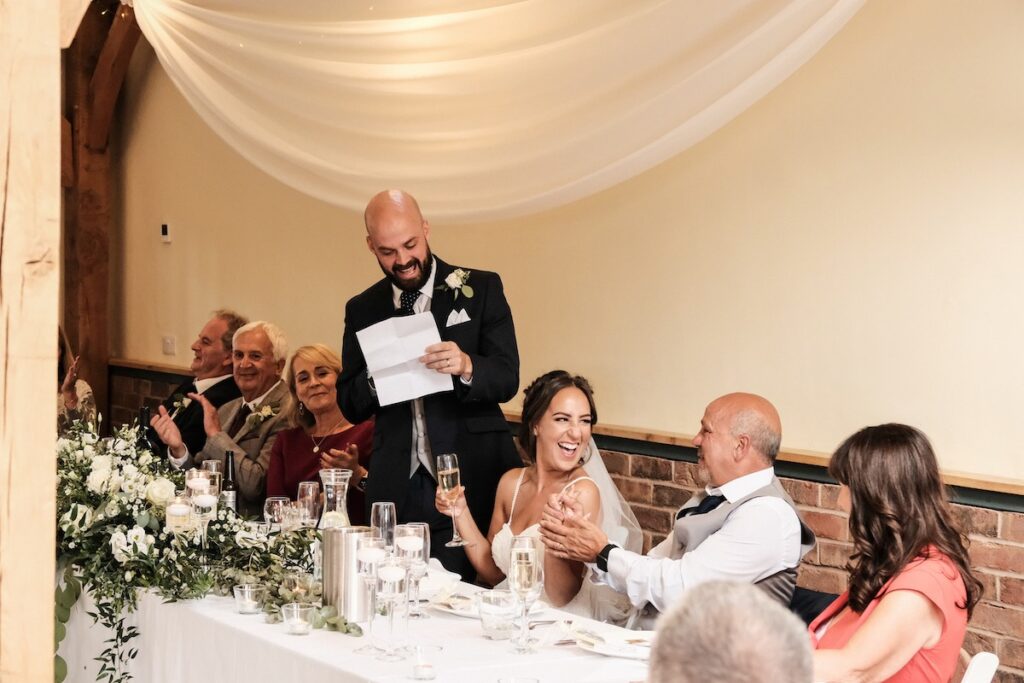 The bride laughing during the groom's speech