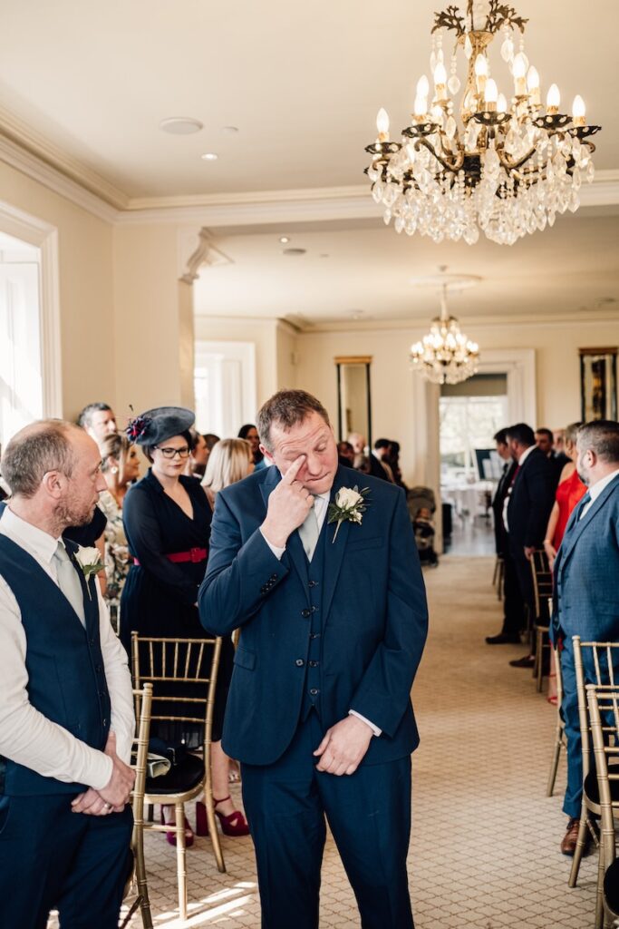 A groom wiping away happy tears