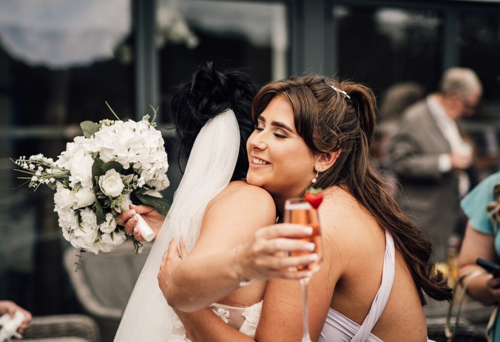 The bride hugs her sister