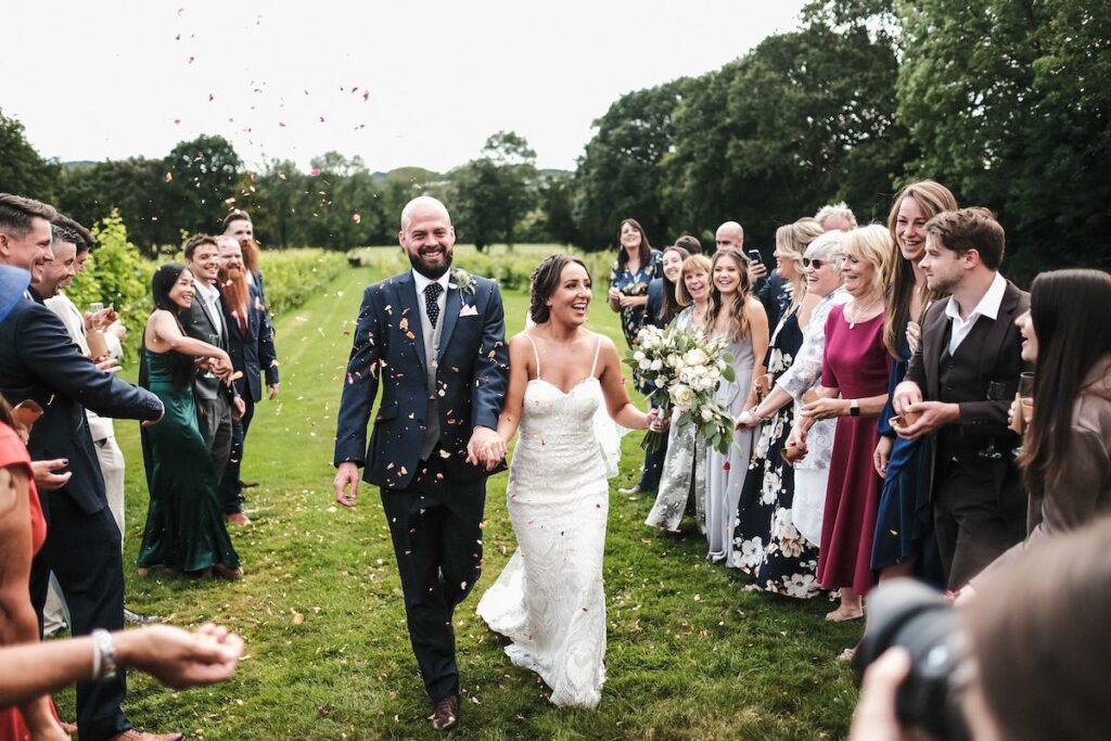 The couple walk through confetti