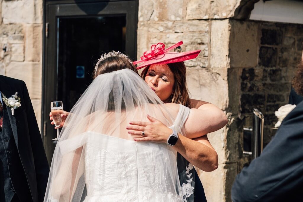 The bride being hugged 