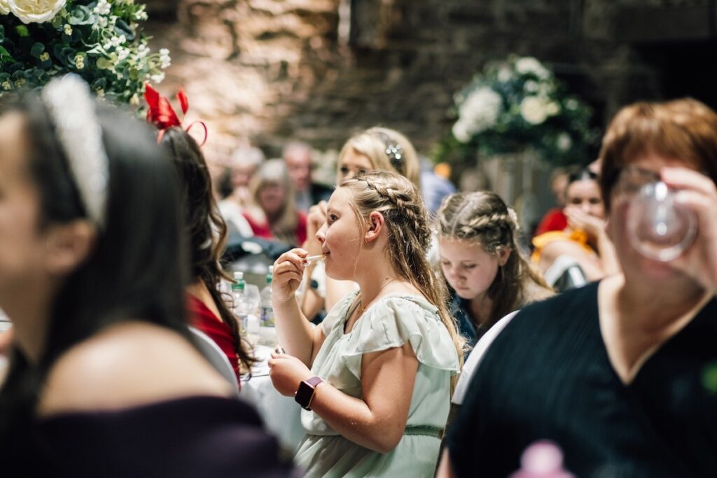 Young wedding guest applying lipstick